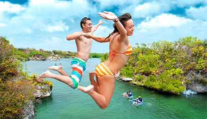 Men and women taking the leap of faith from Xel-Ha's scenic jump into the canal.