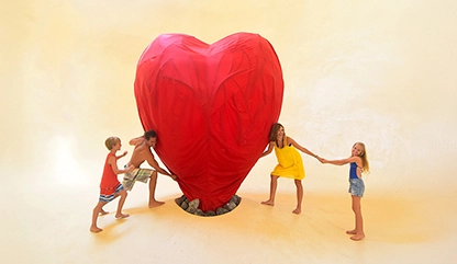 Family posing and hugging the
big red heart at Xenses theme park Riviera Maya.